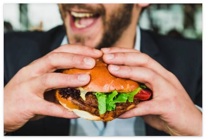 ハンバーガーを食べる男性